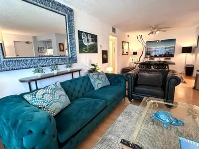 a living room with a blue couch and a mirror at Beverly Estates in Los Angeles