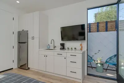 a kitchen with white cabinets and a tv on the wall at Brand New Studio in Mar Vista in Los Angeles