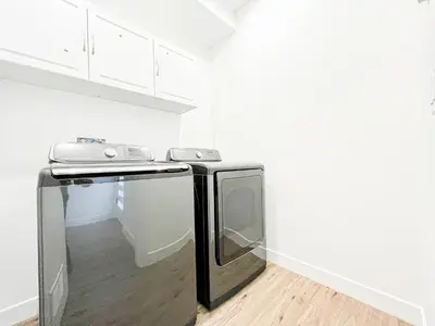 a kitchen with a black refrigerator and a stove at Elegant 4-Bedroom Family Home - Oak2 - LAD in Los Angeles