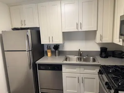 a white kitchen with a sink and a refrigerator at Loft & Two Bedroom Hollywood apartments FREE Parking in Los Angeles