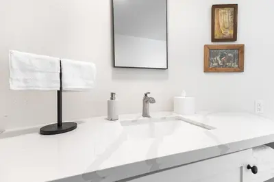 a white bathroom with a sink and a mirror at Camp Nelson Lodge Room 2 in Ponderosa