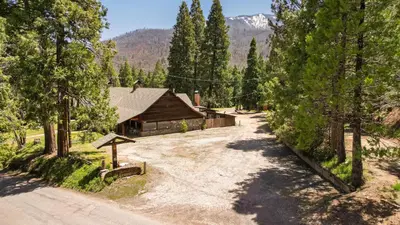 an empty road in front of a log cabin at Suite Meadow @CN Lodge# 7 in Ponderosa