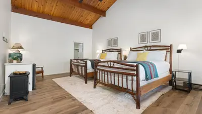 two twin beds in a bedroom with wooden ceilings at Suite Meadow @CN Lodge# 7 in Ponderosa