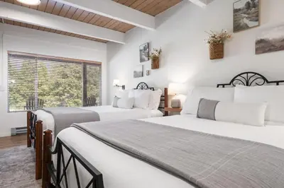 two beds in a bedroom with white walls and a window at Timberline Retreat CN Lodge #3 in Ponderosa