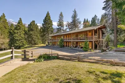 a home in the woods with a fence at Camp Nelson Lodge Room 10 in Ponderosa