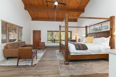 a bedroom with a canopy bed and a couch at Camp Nelson Lodge Room 10 in Ponderosa