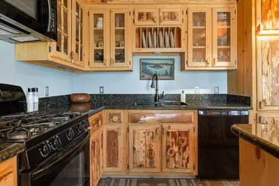 a kitchen with wooden cabinets and a black stove at Little Lakeview Lodge in Big Bear Lake