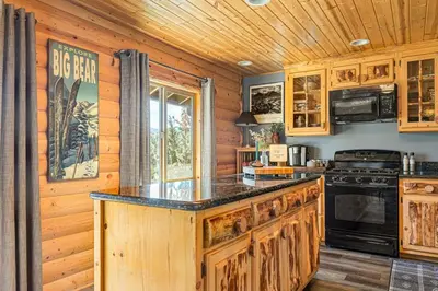 a kitchen with wooden cabinets and a black counter top at Little Lakeview Lodge in Big Bear Lake