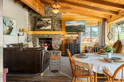 a living room with a table and a fireplace at Little Lakeview Lodge in Big Bear Lake
