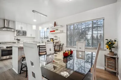 a white kitchen with a glass table and chairs at Cozy single story 2 bdrm family home near the BLVD in Lancaster