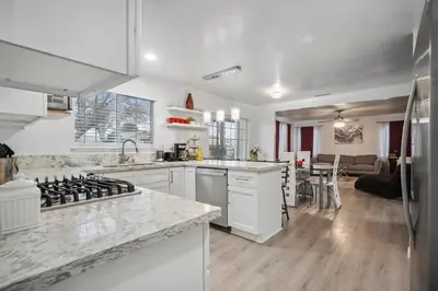 a kitchen with white appliances and a living room at Cozy single story 2 bdrm family home near the BLVD in Lancaster