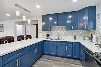 a blue kitchen with white counter tops and blue cabinets at Modern City Ranch 3 bdrm Family Home Access by Dirt Road in Palmdale