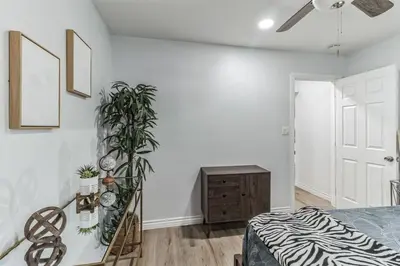a white bedroom with a bed and a plant at Modern City Ranch 3 bdrm Family Home Access by Dirt Road in Palmdale