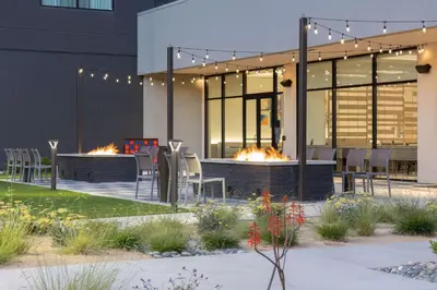 a building with a patio with two fire pits at Homewood Suites by Hilton Cypress Orange County in Cypress