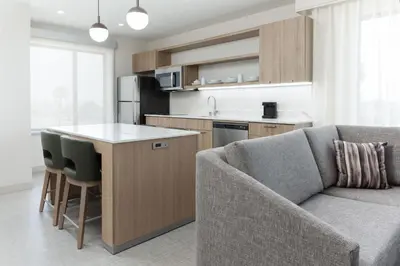 a kitchen and living room with a couch and a table at Homewood Suites by Hilton Cypress Orange County in Cypress