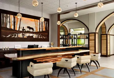 a lobby with a bar with white chairs at Sanctity Hotel Rancho Cucamonga, Tapestry Collection Hilton in Rancho Cucamonga