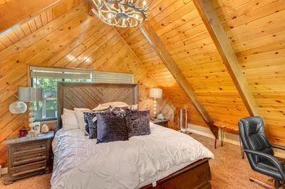 a bedroom with a bed in a log cabin at Lake Arrowhead Cabin with Hot Tub and Mountain Views! in Lake Arrowhead