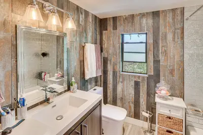 a bathroom with a sink and a toilet and a window at Lake Arrowhead Cabin with Hot Tub and Mountain Views! in Lake Arrowhead
