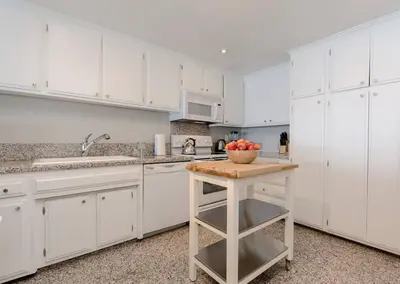 a kitchen with white cabinets and a bowl of fruit on a counter at OCEAN PARADISE SANTA MONICA ADJACENT 2 Bedroom in Malibu