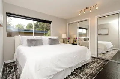 a bedroom with a large white bed and a mirror at SURF-N-SAND 2-Bedrooms, MALIBU in Malibu