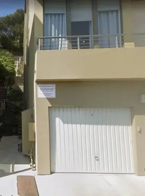 a white garage door with a sign in front of a building at SURF-N-SAND 2-Bedrooms, MALIBU in Malibu