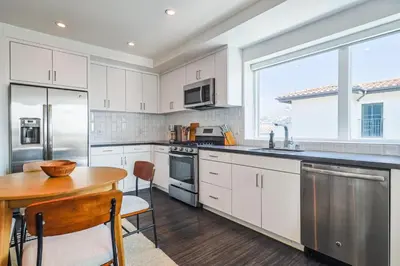 a kitchen with white cabinets and a wooden table at Luxurious 2Bed 2Bath Apartment at Formosa in Los Angeles
