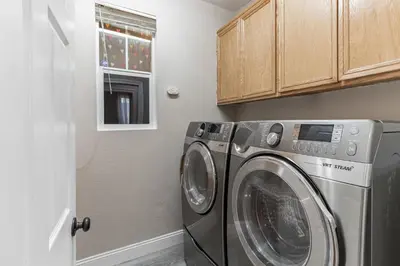 a laundry room with a washing machine and a window at Modern 4BR Oasis, Fireplace, Patio & Spacious Family Room in Palmdale