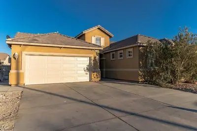 a house with a garage and a driveway at Modern 4BR Oasis, Fireplace, Patio & Spacious Family Room in Palmdale