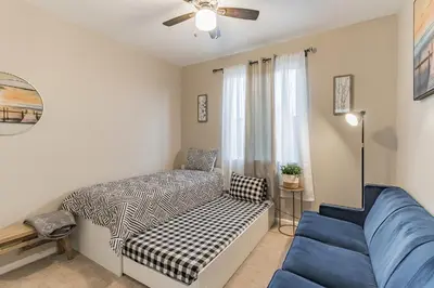 a bedroom with a bed and a blue couch at Modern 4BR Oasis, Fireplace, Patio & Spacious Family Room in Palmdale