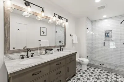 a bathroom with a sink and a toilet and a mirror at Luxe Mountain Retreat Lake Village Close Game Room AC Backs up to trails in Lake Arrowhead