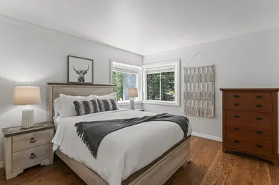 a white bedroom with a bed and two windows at Luxe Mountain Retreat Lake Village Close Game Room AC Backs up to trails in Lake Arrowhead