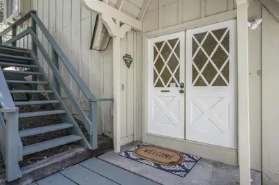 a white door on a house with a staircase at Luxe Mountain Retreat Lake Village Close Game Room AC Backs up to trails in Lake Arrowhead