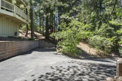 a driveway in front of a house with trees at Luxe Mountain Retreat Lake Village Close Game Room AC Backs up to trails in Lake Arrowhead