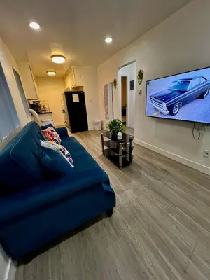 a living room with a blue couch and a flat screen tv at Cozy 2 Bedroom 1 Bathroom Apartment Ideal for Small Group in Koreatown Free Gated Parking Full Kitch in Los Angeles