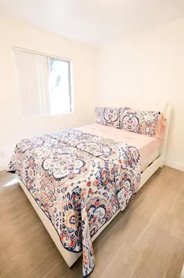 a bedroom with a bed with a flowered blanket at Cozy 2 Bedroom 1 Bathroom Apartment Ideal for Small Group in Koreatown Free Gated Parking Full Kitch in Los Angeles