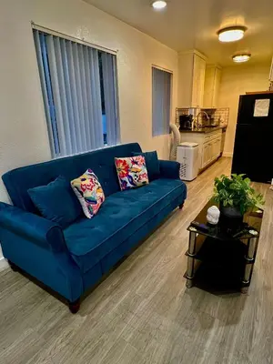 a blue couch in a living room with a kitchen at Cozy 2 Bedroom 1 Bathroom Apartment Ideal for Small Group in Koreatown Free Gated Parking Full Kitch in Los Angeles