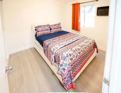 a bedroom with a bed with a comforter and a window at Cozy 2 Bedroom 1 Bathroom Apartment Ideal for Small Group in Koreatown Free Gated Parking Full Kitch in Los Angeles