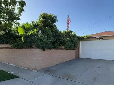 a brick wall with a bush on top of a garage at Alhambra\u7cbe\u54c1\u5957\u623f\u72ec\u7acb\u536b\u6d74 in Alhambra