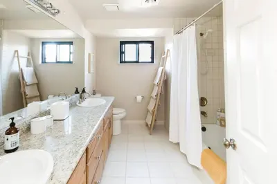 a white bathroom with two sinks and a shower at Cool Cali Vibe - Barefoot Stepping Distance 2 Sand in Oxnard