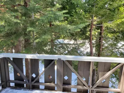 a wooden fence with trees in the background at The Treetop Terrace at The Historic Arrowhead Lodge in Twin Peaks