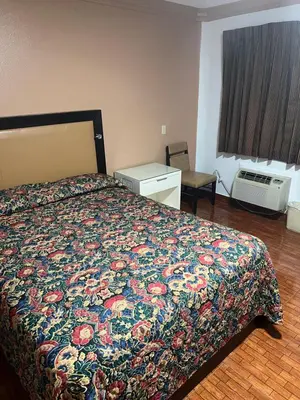 a hotel room with a bed with a colorful bedspread at King Motel in Los Angeles
