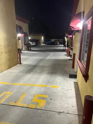 an empty street at night with a stop sign on the road at King Motel in Los Angeles