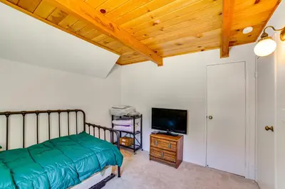 a bedroom with a bed and a flat screen tv at Frazier Park Cabin with Ping-Pong Table, Near Trails in Frazier Park