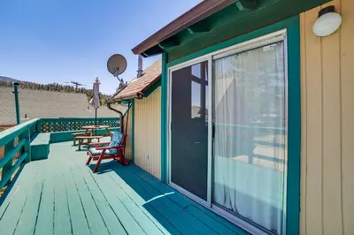 a wooden deck with chairs and a sliding glass door at Frazier Park Cabin with Ping-Pong Table, Near Trails in Frazier Park