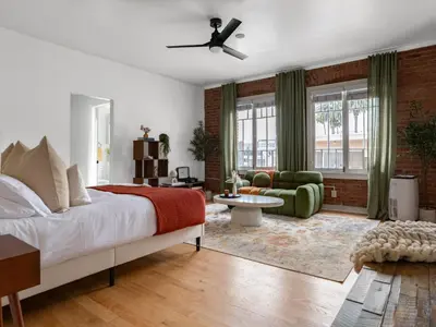 a bedroom with a bed and a living room at The Nirvana Apartment Hotel in Los Angeles