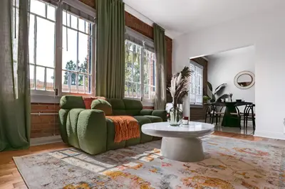 a living room with a green couch and a table at The Nirvana Apartment Hotel in Los Angeles