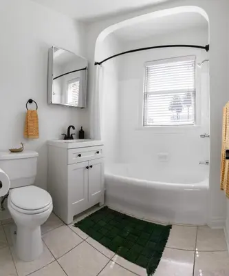 a bathroom with a toilet and a sink and a mirror at The Nirvana Apartment Hotel in Los Angeles