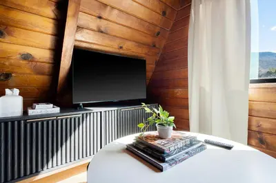 a living room with a tv on a wooden wall at Lake Isabella A frames in Lake Isabella