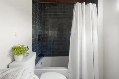 a bathroom with a white shower curtain next to a tub at Lake Isabella A frames in Lake Isabella
