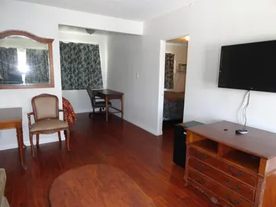 a living room with a flat screen tv and a table at Travel Inn in North Hills